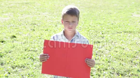 悲伤的男孩站在空空白旗旁视频的预览图