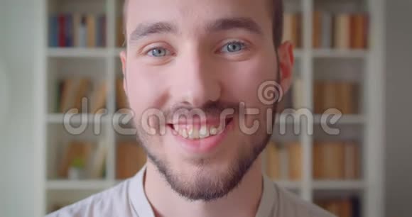 年轻英俊的白种人男学生在大学图书馆里看着镜头开心地笑着的特写镜头视频的预览图