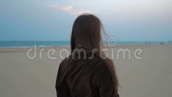 夏海海岸线上一个快乐少女的画像近距离射击慢动作视频的预览图