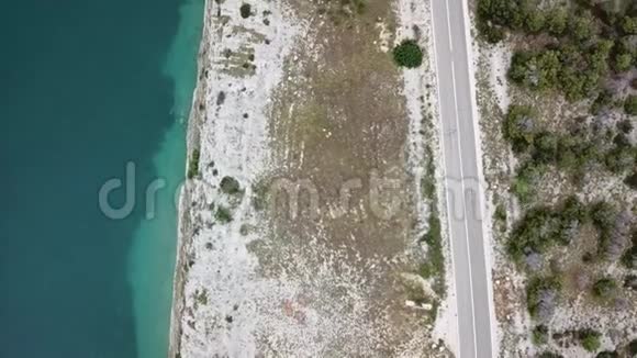 鸟瞰克罗地亚海岸蜿蜒的道路和海湾与晶莹剔透的海洋帕格岛海岸视频的预览图