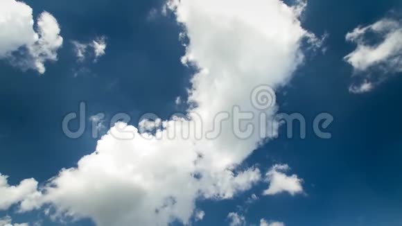 在晴朗的深蓝的天空中缓慢移动的白色蓬松的云视频的预览图