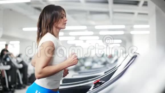 在健身房的单人跑步机上跑步的女人视频的预览图