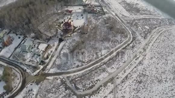 冬天的乡村景象有房子森林和雪田空中景观视频的预览图