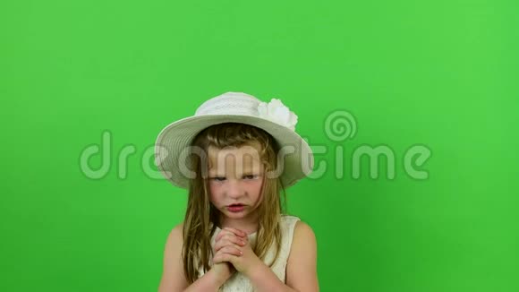 可爱的小女孩在色度键背景上唱歌穿着浪漫裙子的小女孩白色帽子和婚纱视频的预览图