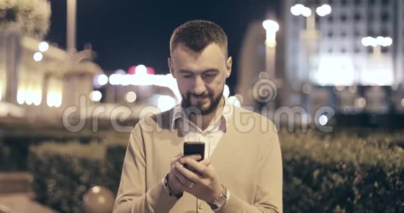 留胡子的人在户外使用智能手机视频的预览图