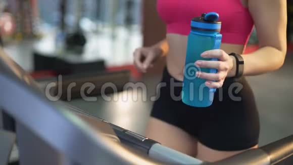 健康健康的女士在跑步机上运动喝点茶视频的预览图