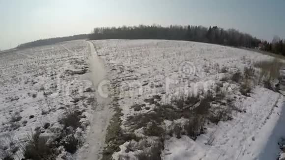森林附近有广阔的雪田的村庄鸟瞰视频的预览图