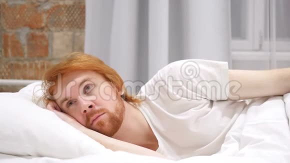 思考在床上躺在一边做梦的男人视频的预览图