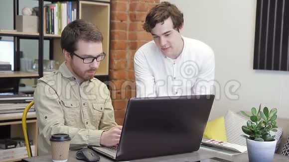 在办公室里两个年轻人在电脑前工作视频的预览图