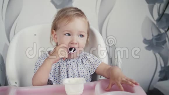 女孩在厨房里吃酸奶小婴儿食品孩子用勺子吃饭视频的预览图
