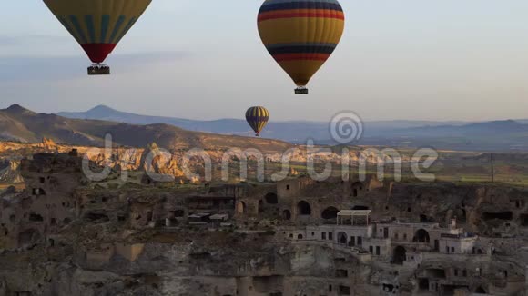 许多热气球飞过戈尔梅的山谷土耳其飞越玫瑰谷古洞城视频的预览图