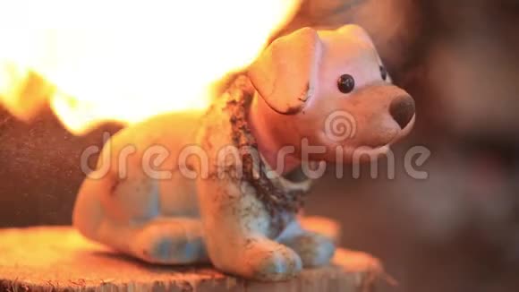 旧玩具狗在炽热的火焰下融化慢动作视频的预览图