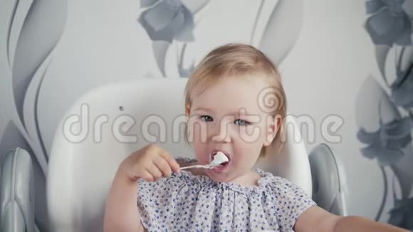 女孩在厨房里吃酸奶小婴儿食品孩子用勺子吃饭视频的预览图