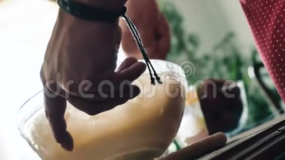 男性的手在玻璃碗里搅拌面团视频的预览图