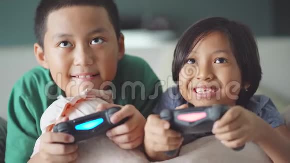 两个快乐的孩子在玩游戏机视频的预览图