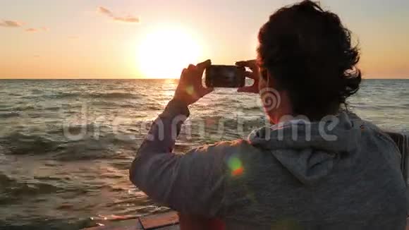 年轻人拍摄太阳从地平线落下的三张照片视频的预览图