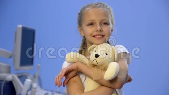 医院里带着泰迪熊的女孩对着镜头微笑视频的预览图