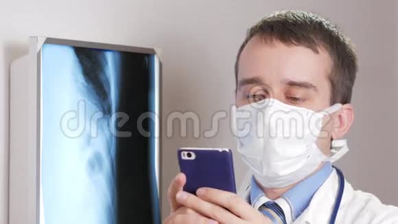 一位戴面膜的年轻医生在诊所里用电话一名男子记录了一名病人x线的结果视频的预览图