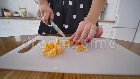 女人在家庭厨房里吃橘子和木厨房板在家做饭家庭气氛视频的预览图