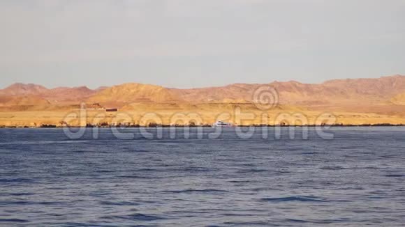 一艘游船在荒无人烟的海岸附近航行视频的预览图