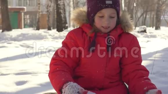 快乐的孩子在冬天的雪地里玩耍穿着暖和的衣服在冬天的公园里散步和玩耍的小女孩视频的预览图