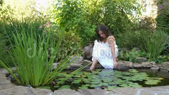 女孩在池塘里拿起一壶水视频的预览图