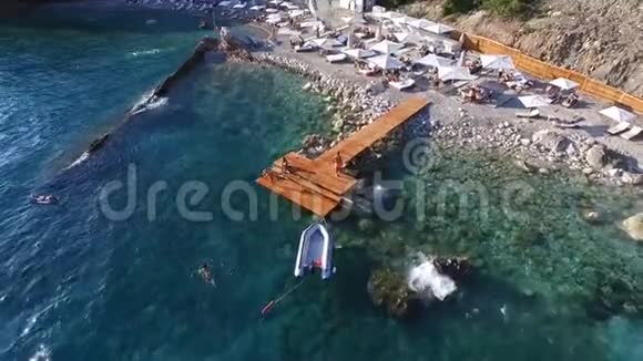 在海滩附近有一艘充气船的空中观光码头视频的预览图