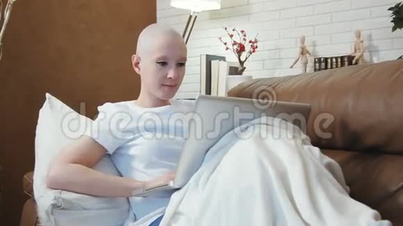 癌症病人躺在沙发上用笔记本电脑视频的预览图