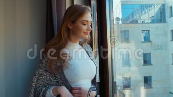 年轻开朗的女人站在窗边视频的预览图