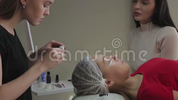 美丽的年轻女孩欣赏睫毛这是她在美容院里积累起来的视频的预览图