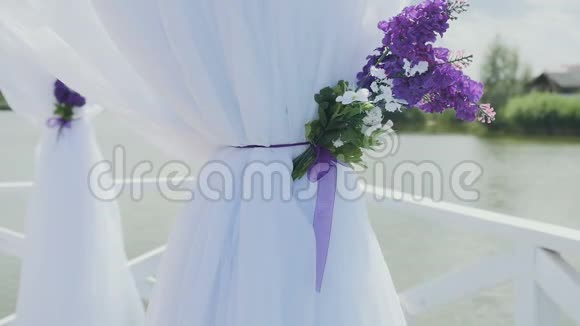 女性的手触摸带有鲜花的白色窗帘婚礼属性视频的预览图