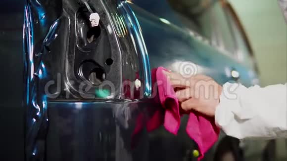 加油站的专家在涂胶膜后用抹布清洗汽车视频的预览图