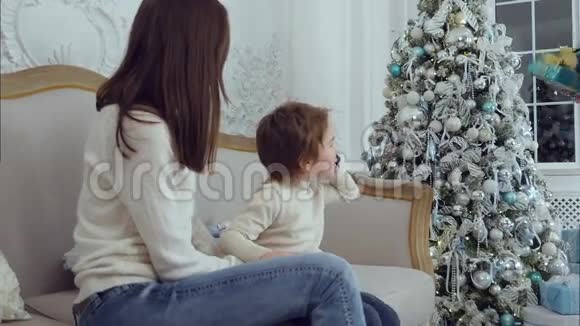 小儿子一边打电话一边爸爸一边拿圣诞礼物给儿子和妻子视频的预览图