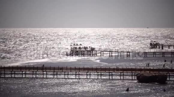 人们站在靠近公海的码头上视频的预览图