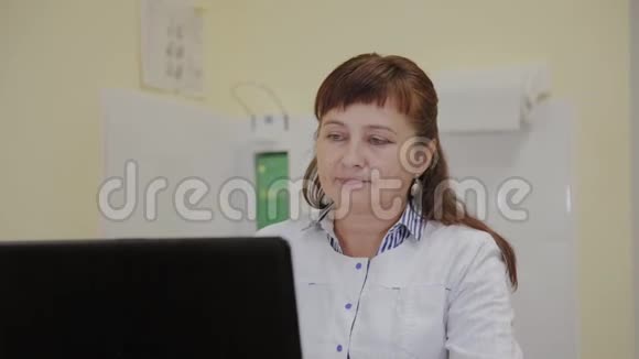 一位在诊所电脑工作的老年医生视频的预览图