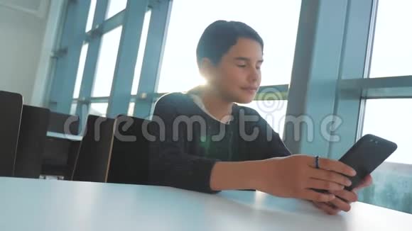 十几岁的女孩正在餐桌旁的一家咖啡馆里用信使的生活方式聊天视频的预览图