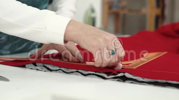 那个女人正在布料上涂上一种图案衣服的设计者用红布画粉笔视频的预览图