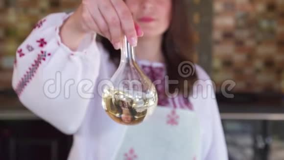 在准备沙拉之前一个女孩在烧瓶里搅拌橄榄油慢动作视频的预览图