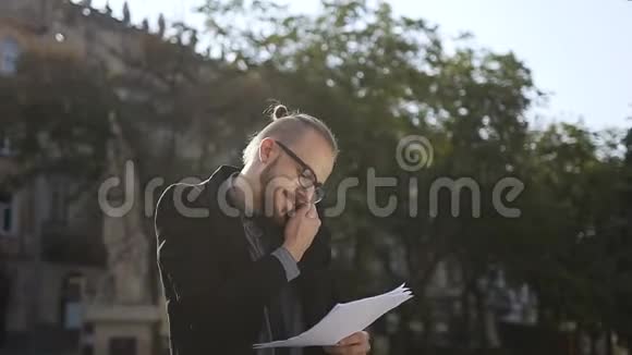 一个戴眼镜的年轻人手里拿着文件视频的预览图