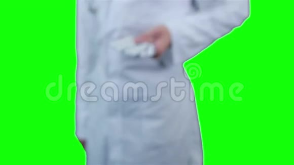 无法辨认的医生的手把药片放进照相机里竖起大拇指绿色屏幕视频的预览图
