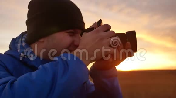 大自然中的摄影师拿着相机拍照视频的预览图