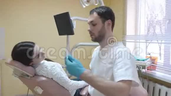 漂亮的年轻女人坐在诊所的牙科椅上医生检查口腔史泰迪康射击视频的预览图