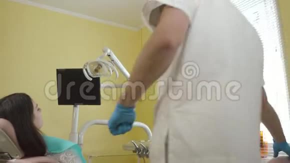 男性牙医为牙科诊所的一名女性病人的检查做准备视频的预览图