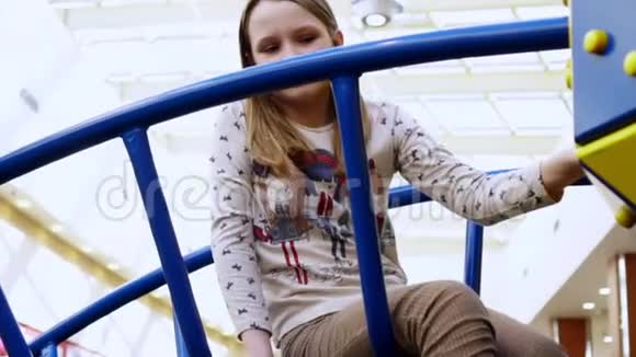 那个开朗的女孩金发在操场上的梯子上玩耍视频的预览图
