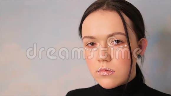 化妆的女孩的肖像一个用球装饰的模特的脸视频的预览图