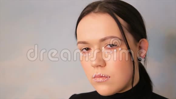化妆的女孩的肖像一个用球装饰的模特的脸视频的预览图