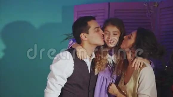 幸福的家庭父母亲吻女儿圣诞节背景的概念视频的预览图