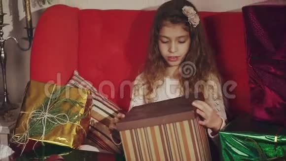 快乐的女孩打开她的圣诞礼物礼物的概念视频的预览图