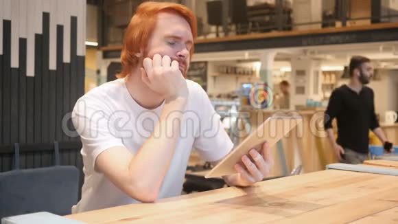 咖啡厅使用平板电脑的休闲红头胡子男视频的预览图
