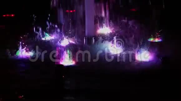色彩斑斓的音乐喷泉在夜晚闪烁着不同的色彩视频的预览图